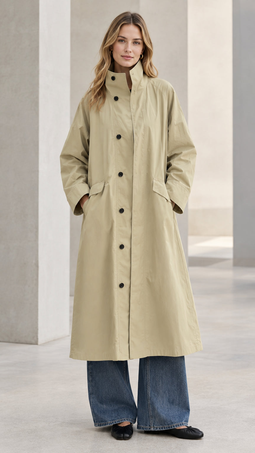 Front full-length view of model wearing Khaki longline stand-collar trench coat with wide-leg jeans