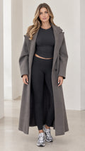 Full front view of model wearing charcoal grey oversized maxi overcoat with black athleisure set and sneakers