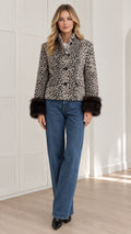 Front full view of woman wearing beige leopard print jacket with dark fur cuffs and wide leg jeans