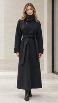 Front view of woman wearing full length black maxi overcoat with high neck and belted waist