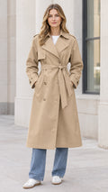 Front full-length view of woman wearing beige double-breasted long trench coat with waist tie