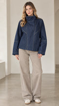 Front view of model wearing dark blue high neck denim jacket with contrast seams and wide leg pants