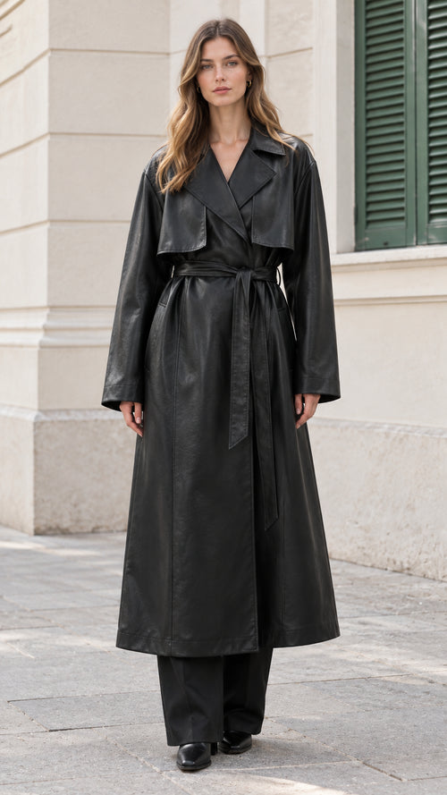 Front view of model wearing black belted faux leather maxi trench coat