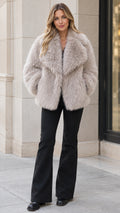 Front view of model wearing light grey shaggy faux fur coat with black flare pants