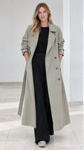 Front full length view of model wearing sage green long double breasted trench coat