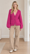 Front full-length view of model wearing fuchsia V-neck button-front knit cardigan with beige pants