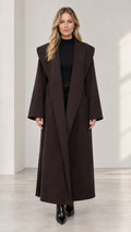 Front view of woman wearing dark brown wide shawl lapel maxi overcoat
