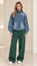 Front view of model wearing blue washed jacket with green wide-leg pants