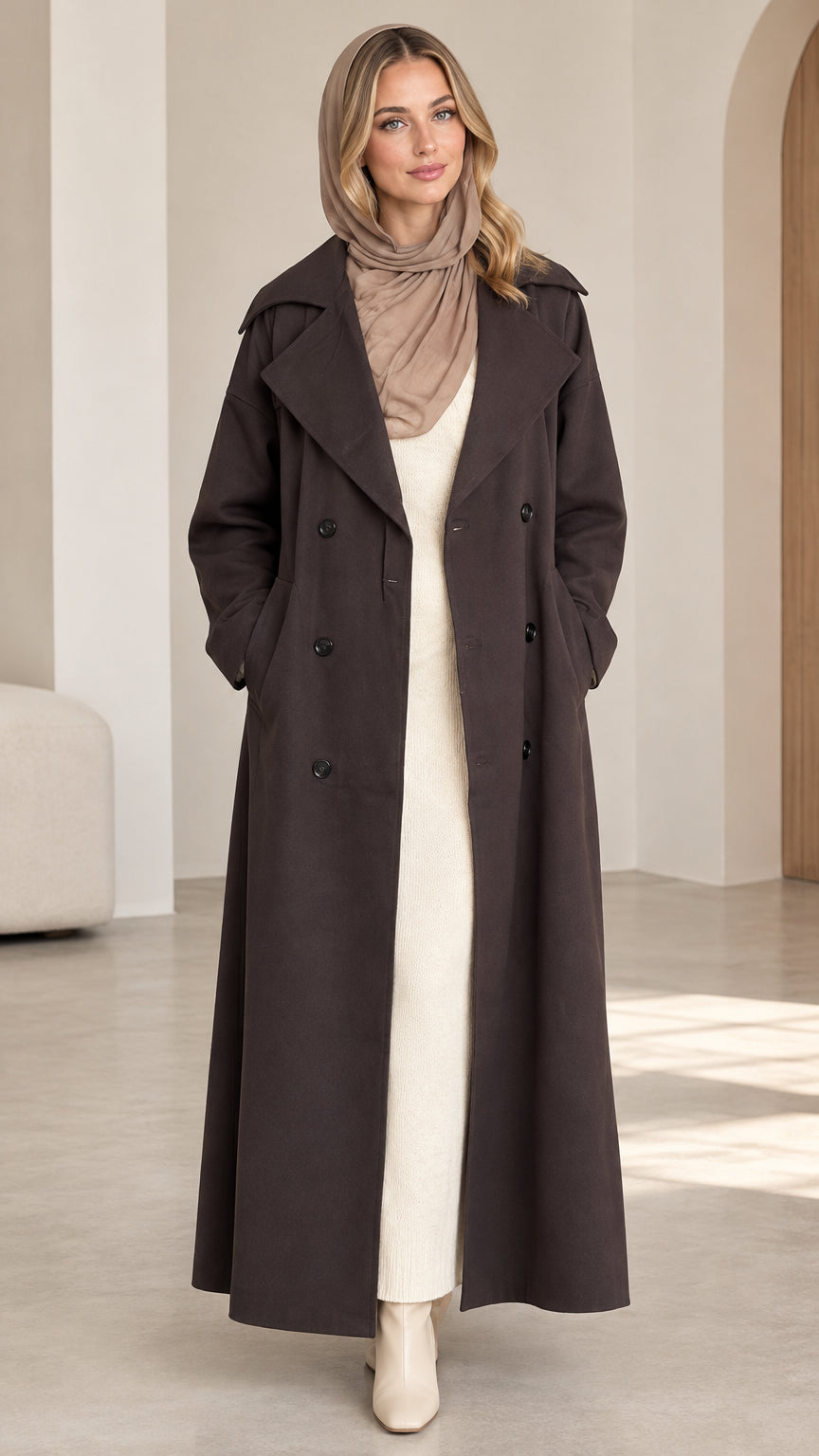 Front full view of woman wearing dark brown double-breasted maxi trench coat