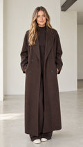 Front full-length view of woman wearing dark brown double-breasted maxi overcoat
