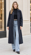 Front full view of woman wearing long Navy Blue single-breasted trench coat with jeans and black top