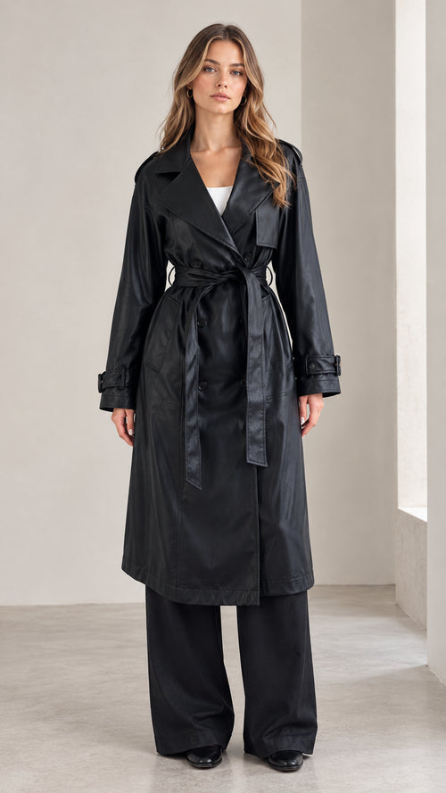 Full front view of a woman modeling the black belted trench coat and wide-leg pants set