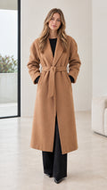 Front view of model wearing a camel long belted overcoat
