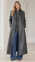 Front full-length view of model wearing charcoal grey faux leather maxi trench coat with notch lapel and jeans