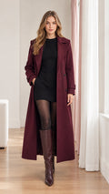 Front full view of woman wearing burgundy longline overcoat with black dress and boots