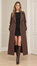 Front full-length view of model wearing a brown double-breasted maxi trench coat with boots