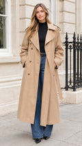 Front full view of a woman wearing a khaki longline double-breasted trench coat with a belt