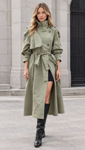 Front view of model wearing sage green maxi belted trench coat with high collar