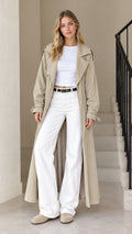Front full-length view of model wearing a Khaki maxi trench coat open over white top and pants