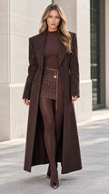 Front full-length view of a woman wearing a tailored chocolate brown maxi overcoat
