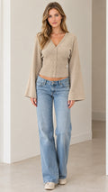 Full front view of model wearing beige V-neck bell sleeve knit cardigan with wide leg jeans