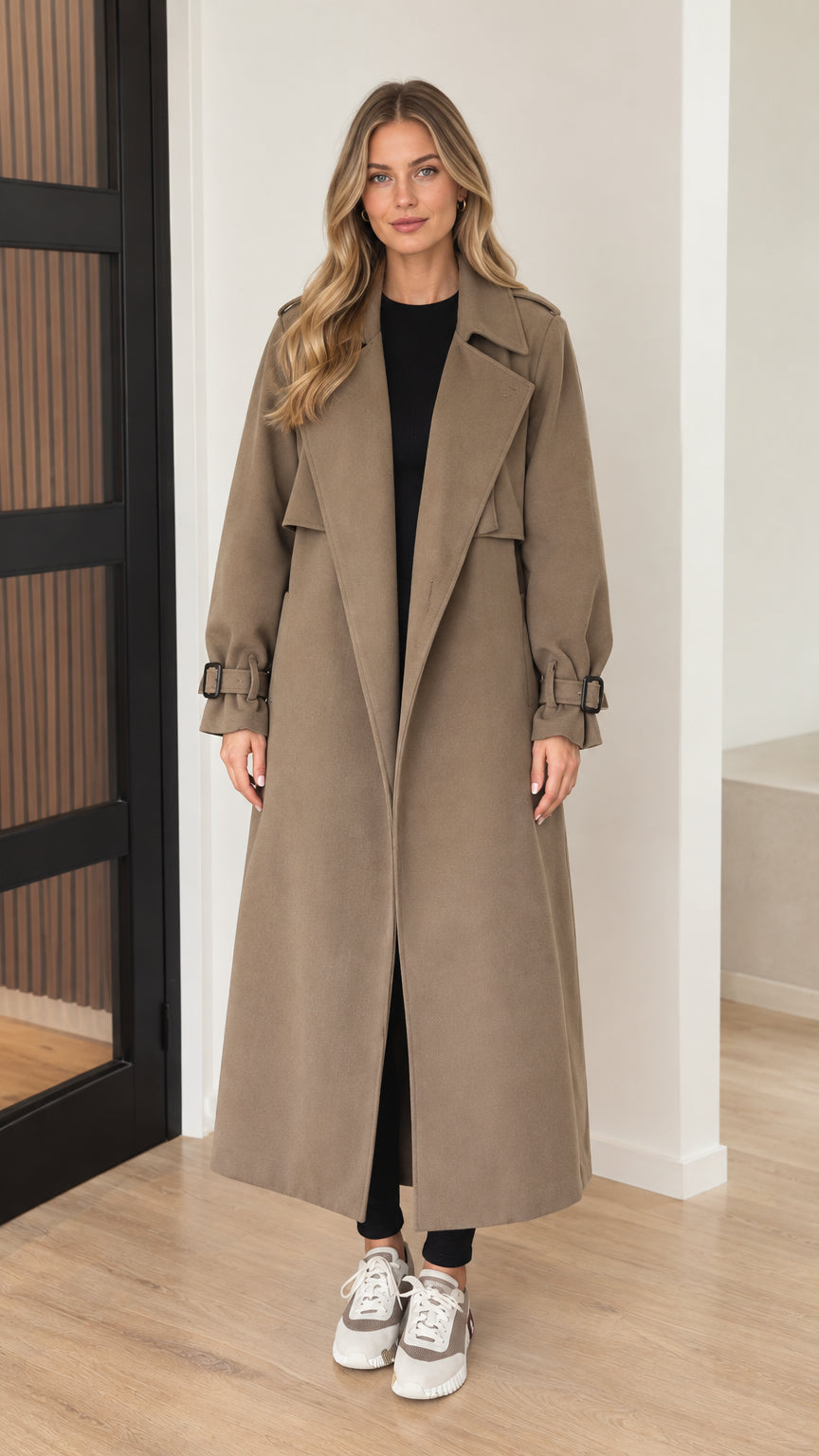 Front view of model wearing long taupe belted trench coat