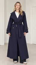 Front full-length view of woman wearing navy blue maxi belted trench coat