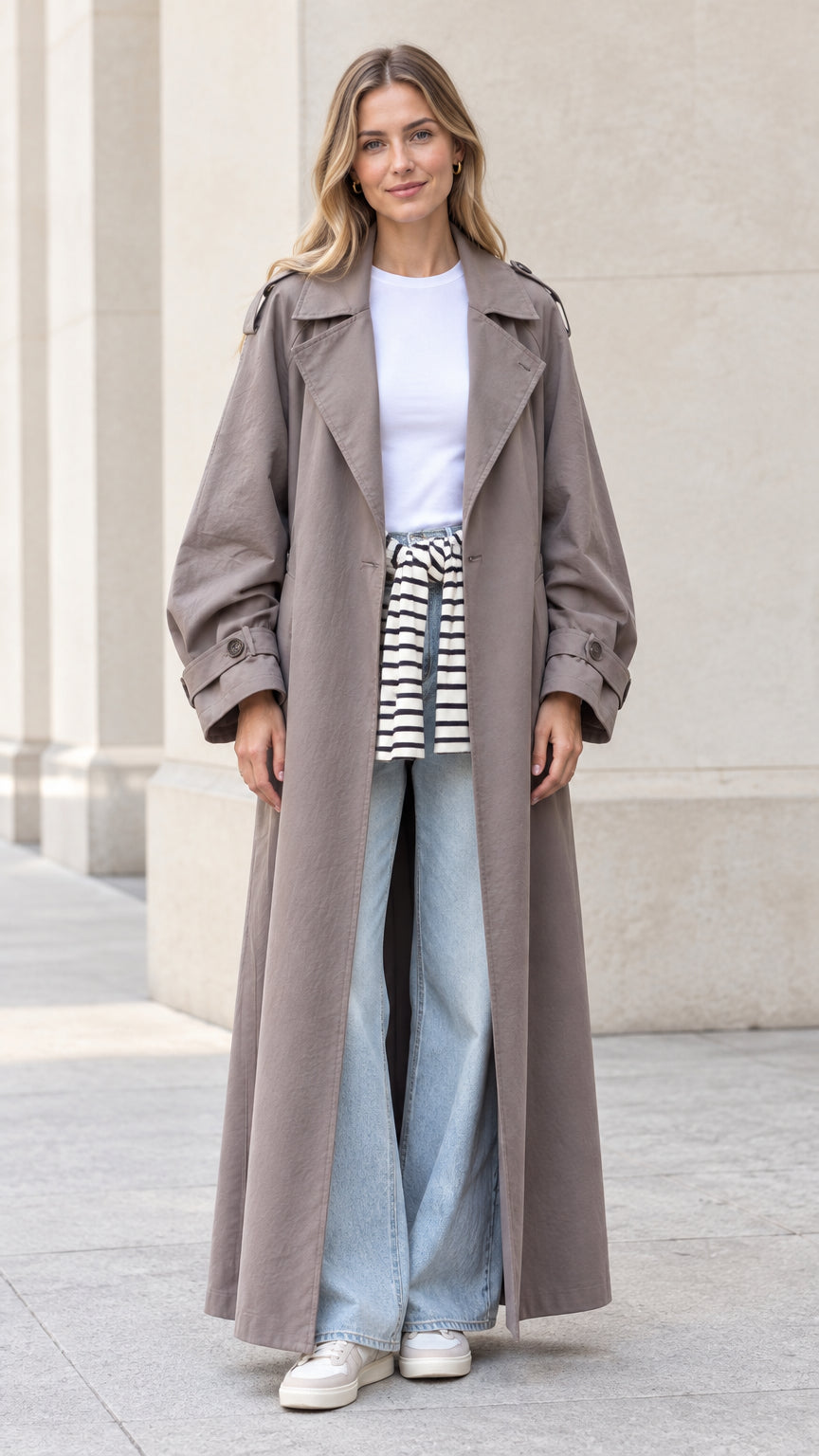 Front full view of woman wearing taupe oversized maxi trench coat with denim jeans
