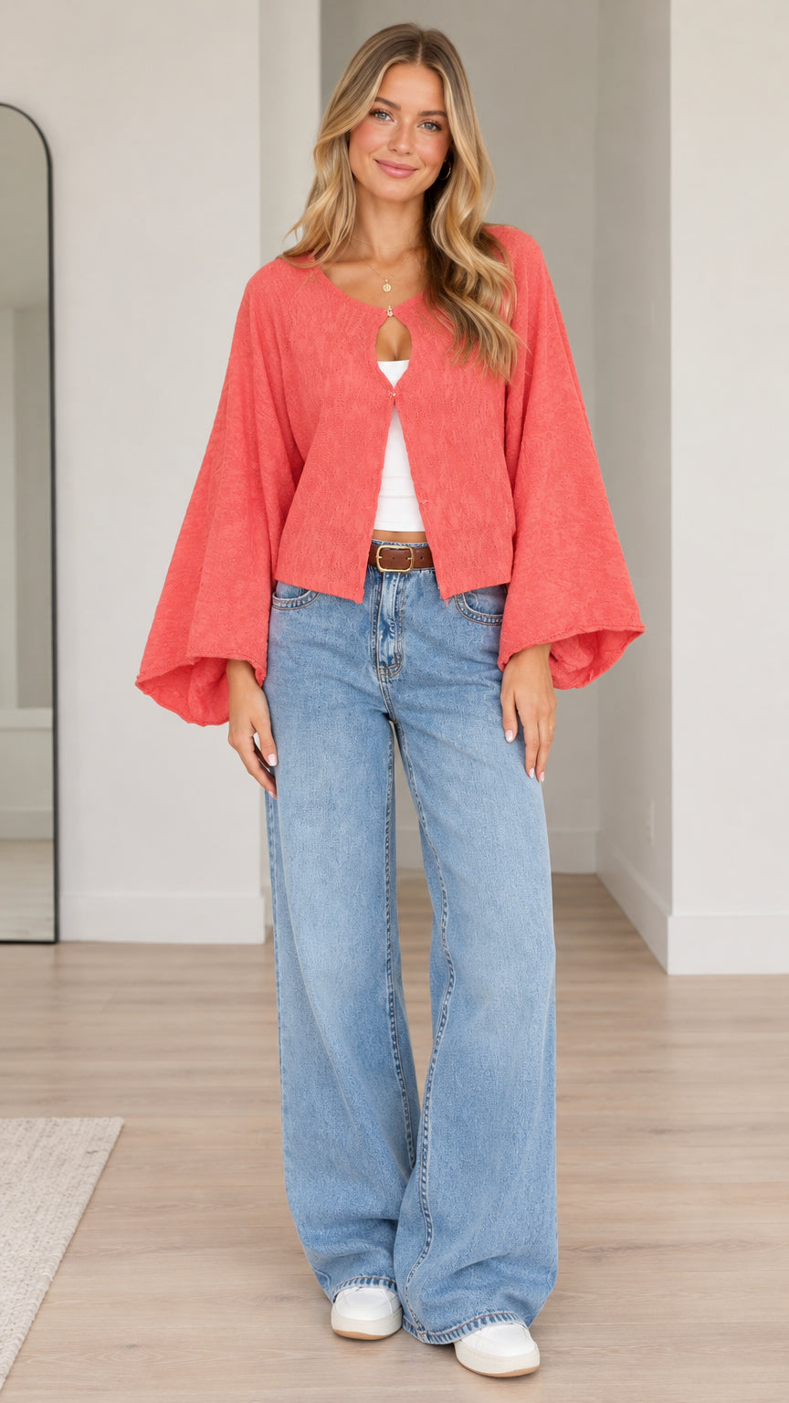 Front view of model wearing coral textured bell sleeve cardigan with wide leg jeans