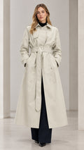 Front view of woman wearing Light Beige double-breasted maxi trench coat with tied belt
