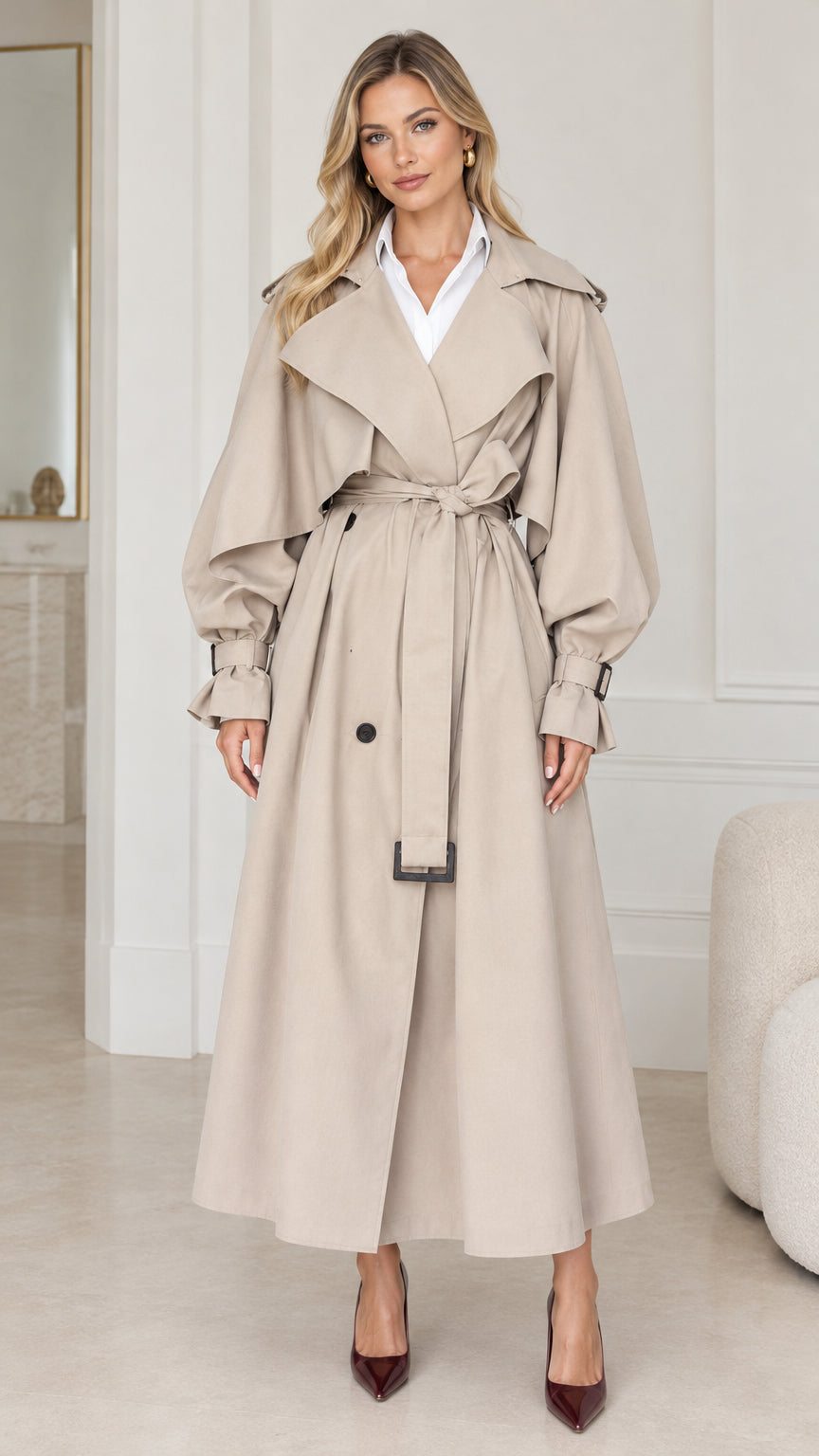 Front view of woman wearing oversized beige maxi trench coat with tie belt