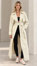 Front full-length view of model wearing cream maxi trench coat with belt