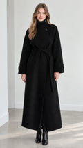 Front view of model wearing black high neck belted maxi overcoat