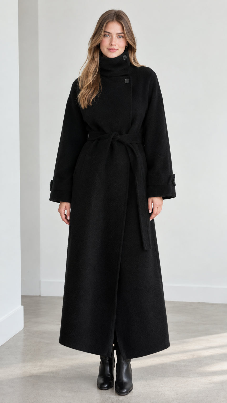 Front view of model wearing black high neck belted maxi overcoat
