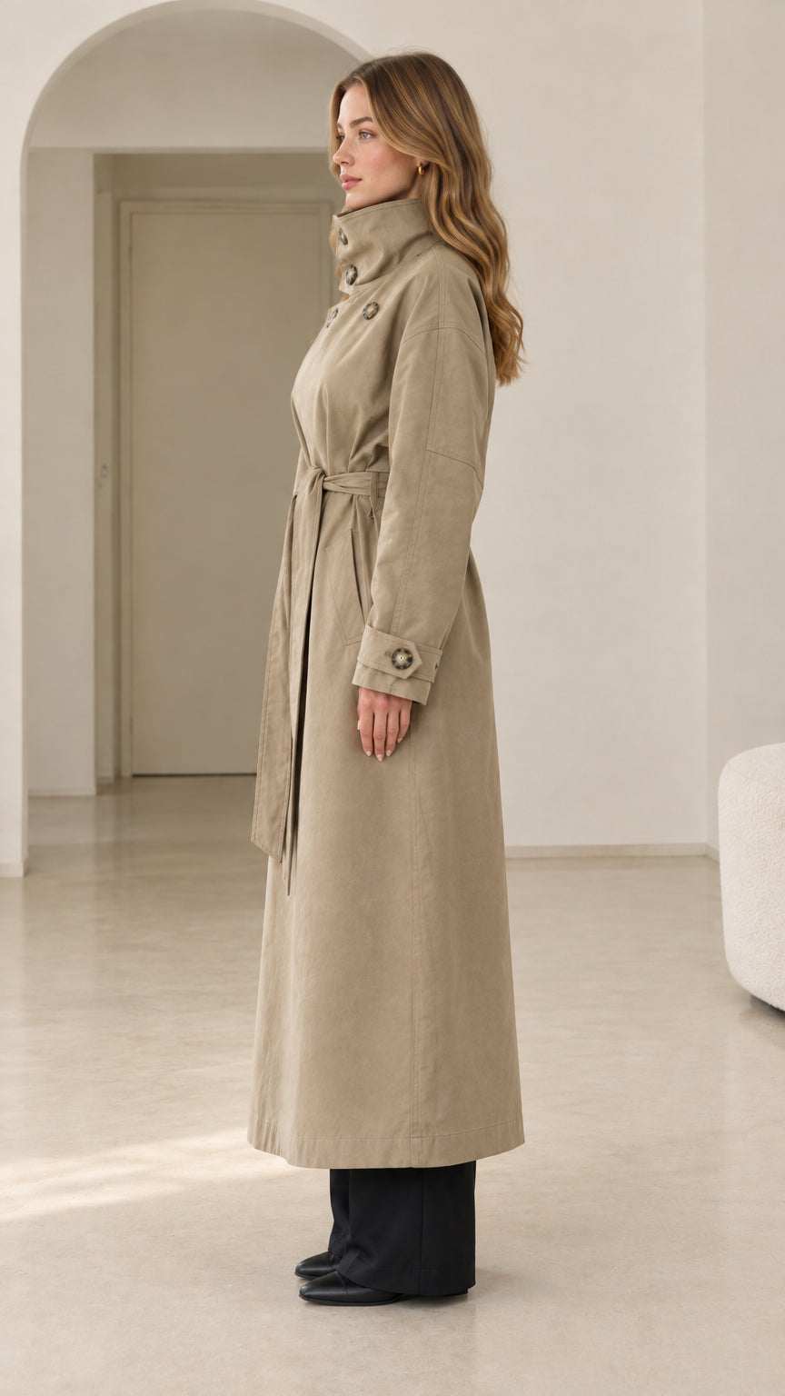 Side profile view of woman wearing khaki maxi longline trench coat