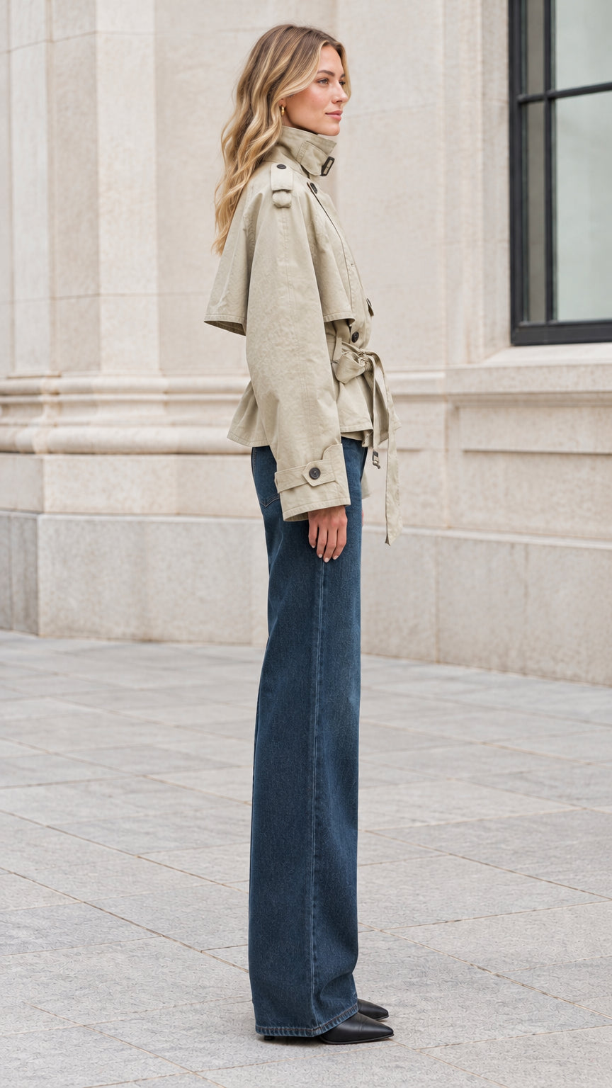 Side profile of woman in sage green cropped trench jacket showing structured sleeves and belt detail
