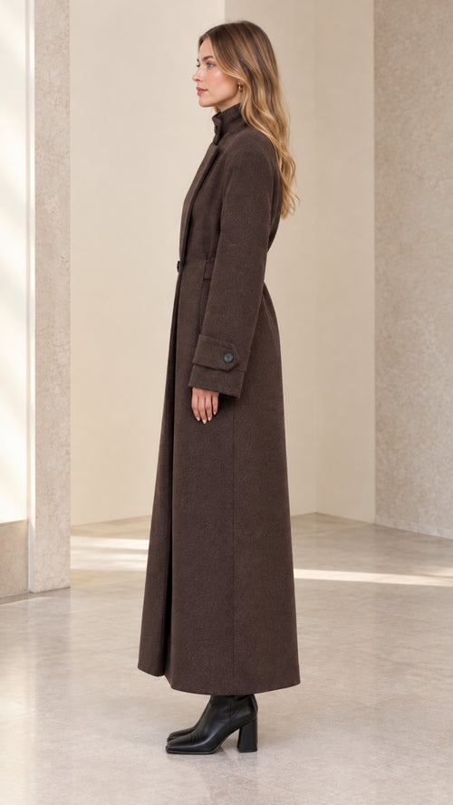 Side profile view of model wearing brown longline tailored maxi coat with belted waist