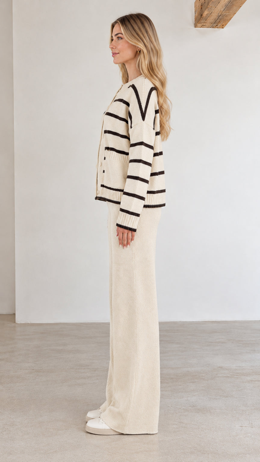 Side profile view of cream striped knit sweater and relaxed pants co-ord set