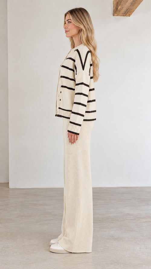 Side profile view of cream striped knit sweater and relaxed pants co-ord set