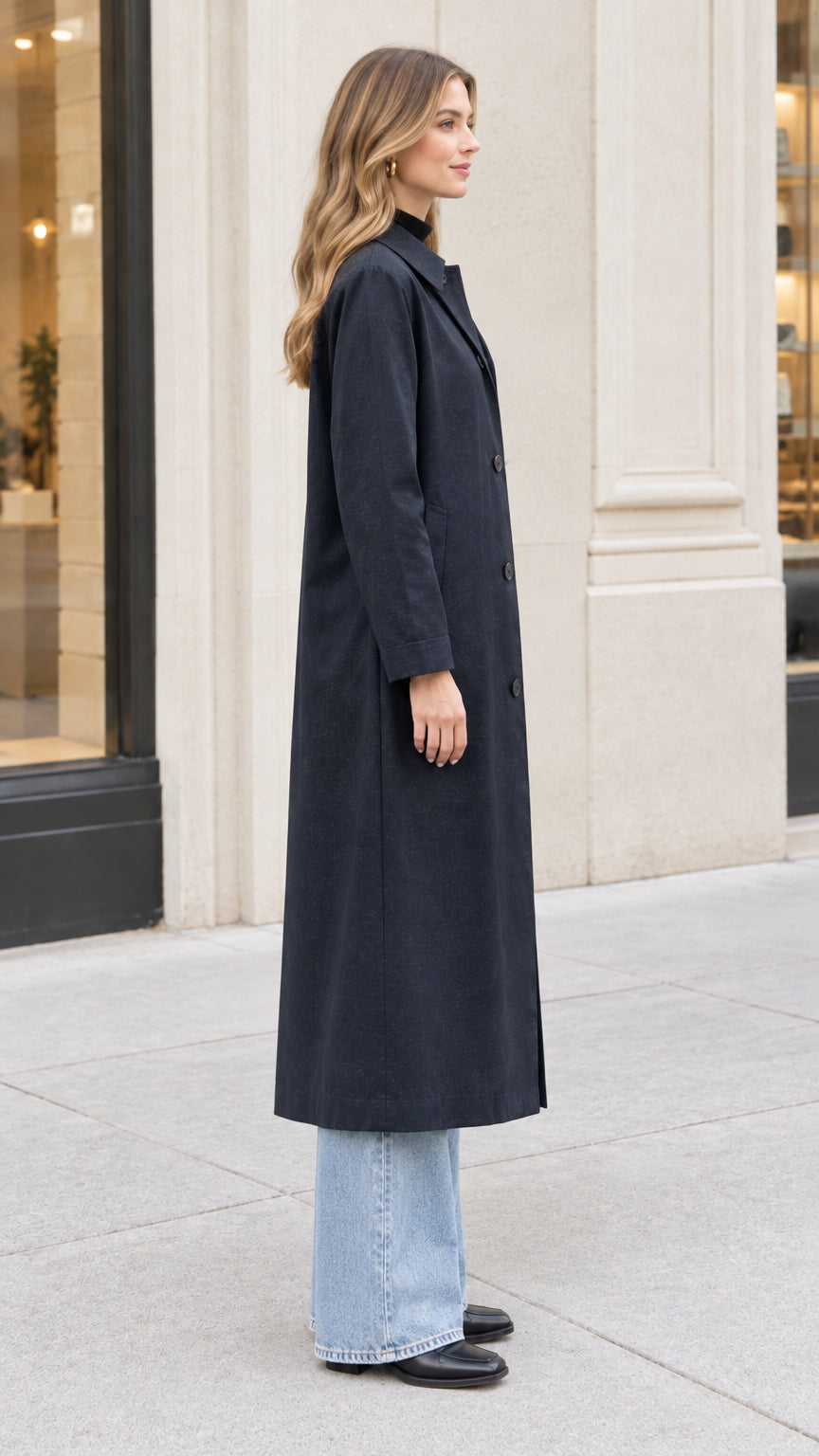 Side profile view of woman wearing long Navy Blue overcoat