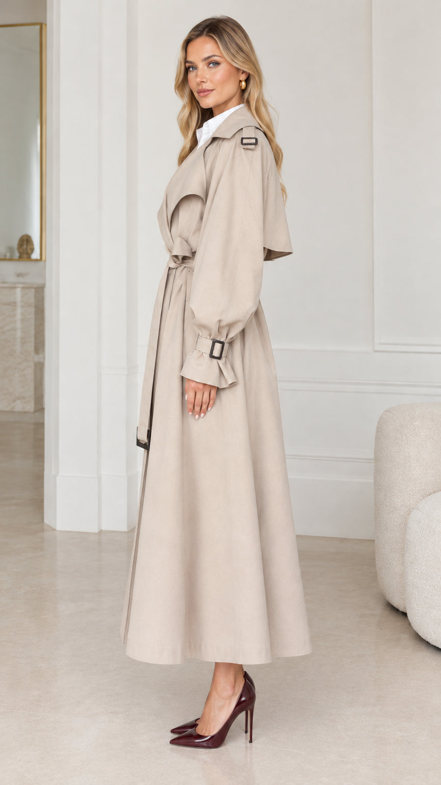 Side profile view of woman modeling long beige trench coat with lantern sleeves