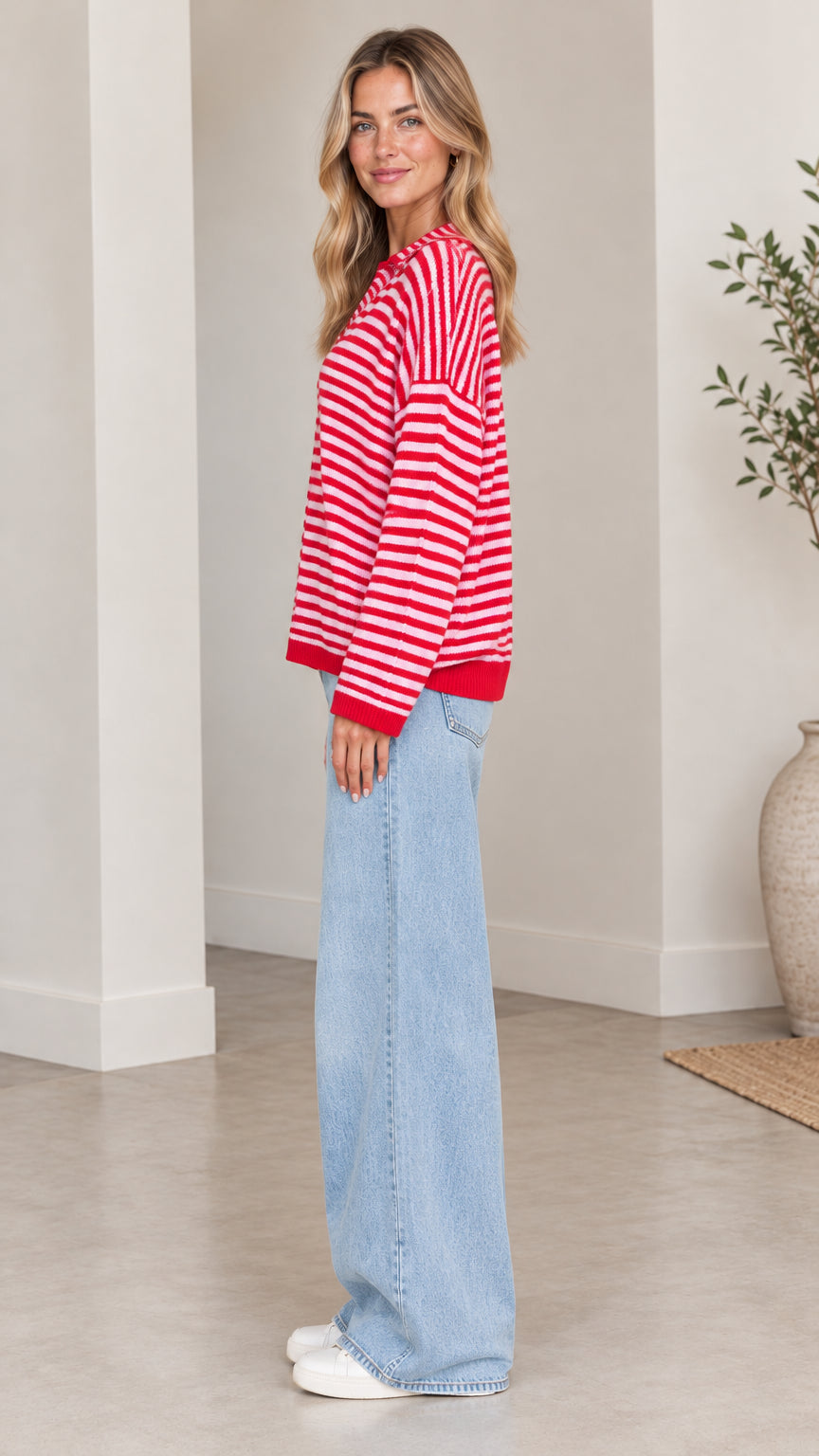 Side full-length view of woman wearing red and white striped cardigan sweater