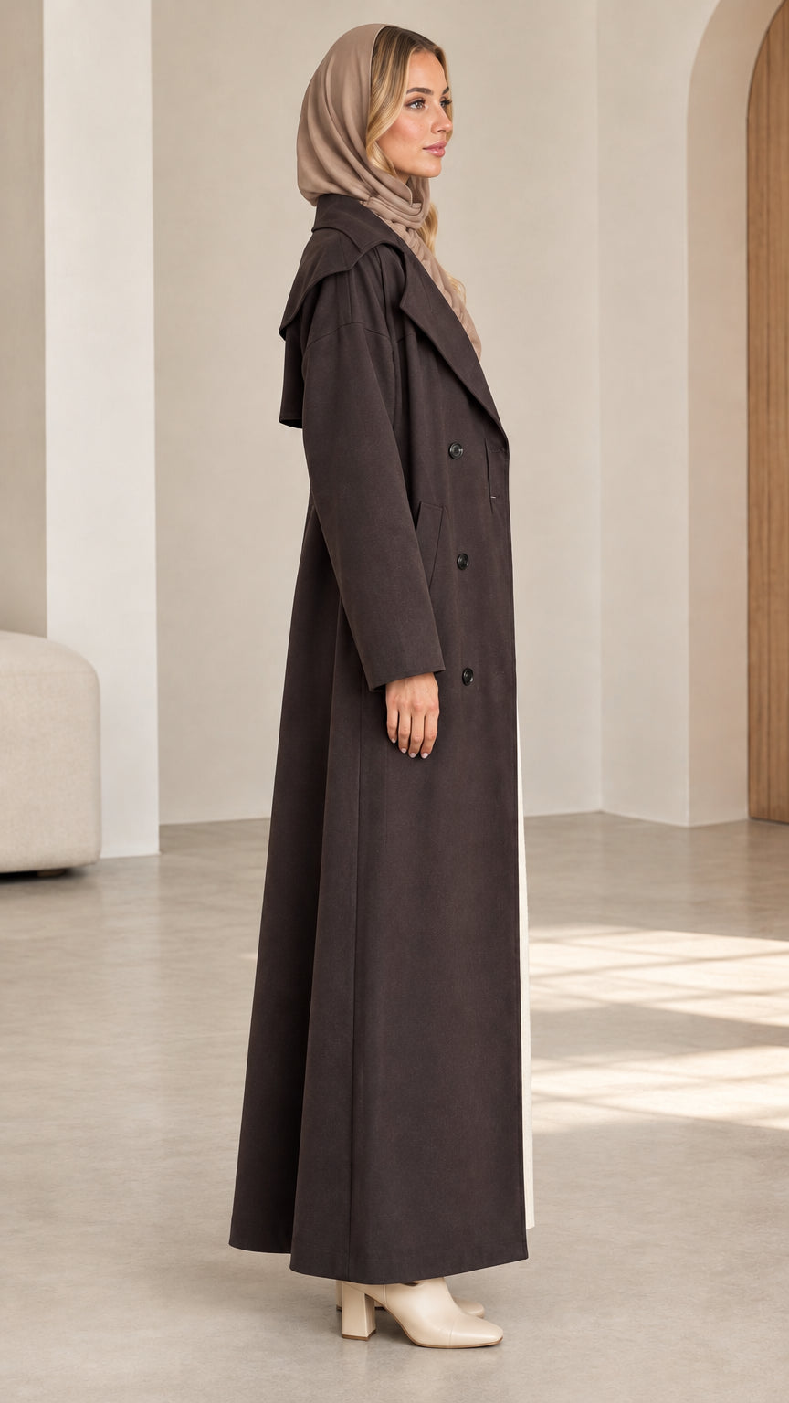 Side profile of woman wearing dark brown full-length duster trench coat