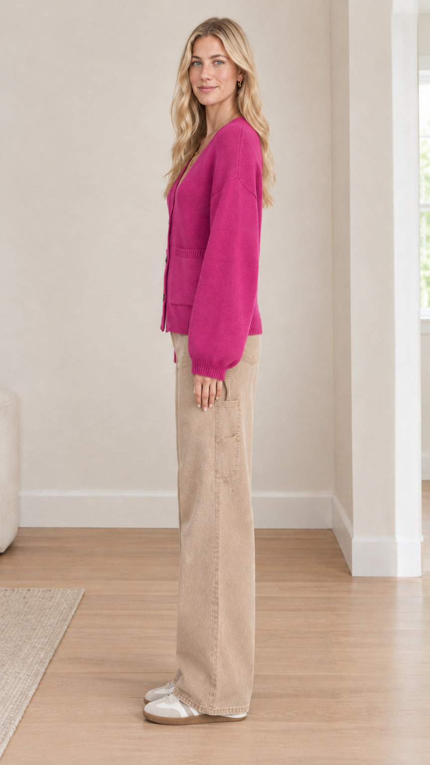 Side profile view of model wearing fuchsia knit cardigan with balloon sleeves