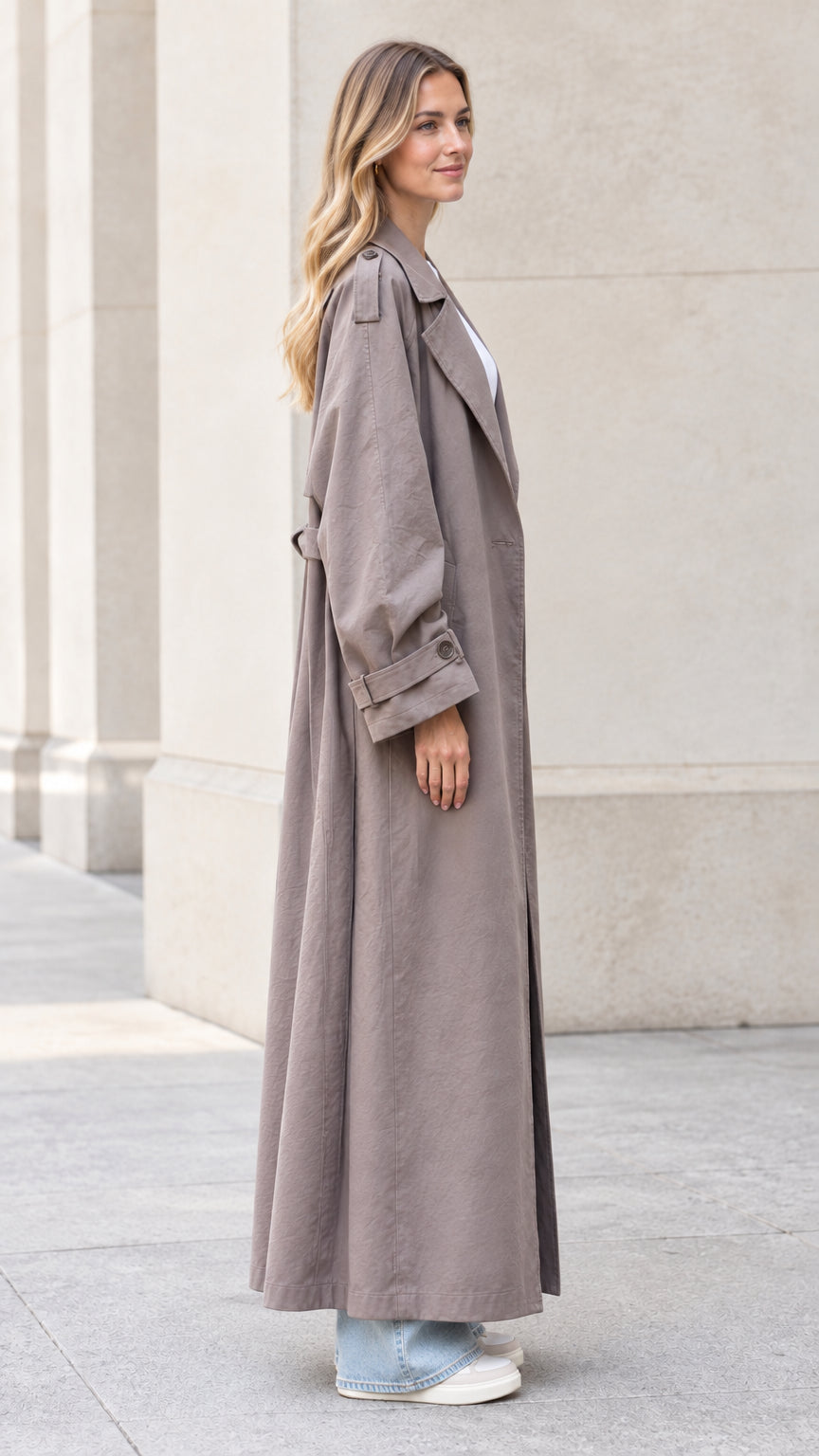 Side profile view of taupe full-length duster trench coat