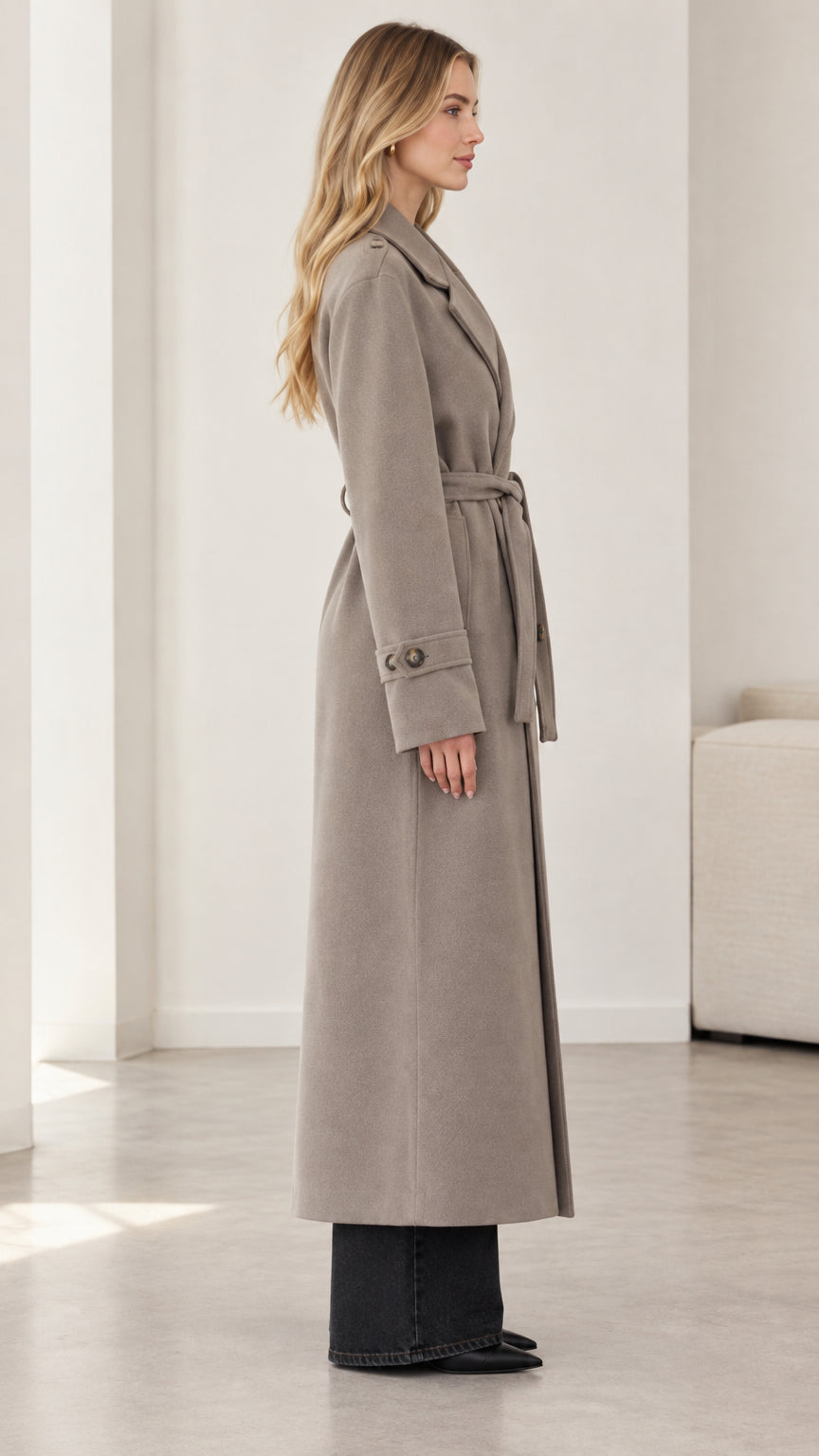 Side profile view of model wearing taupe longline belted overcoat