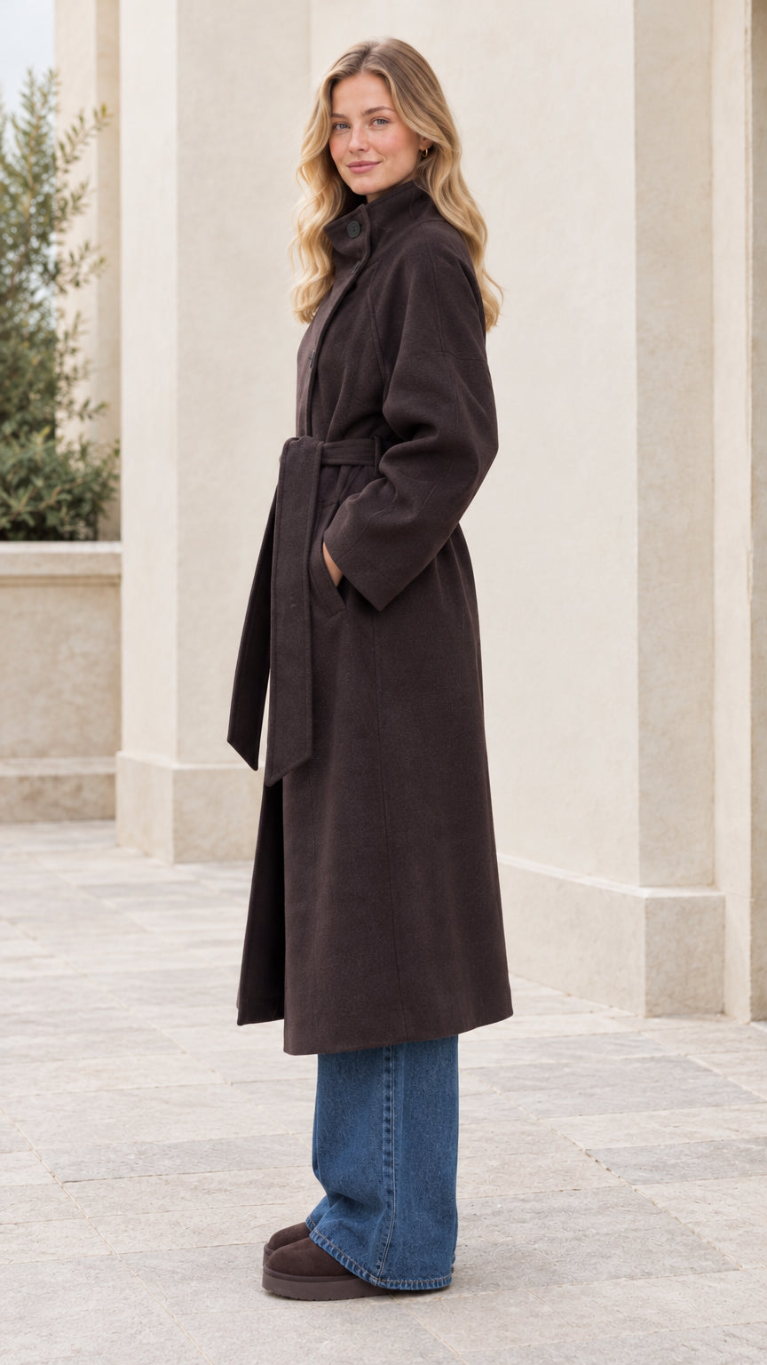 Side profile view of woman wearing the dark brown belted overcoat