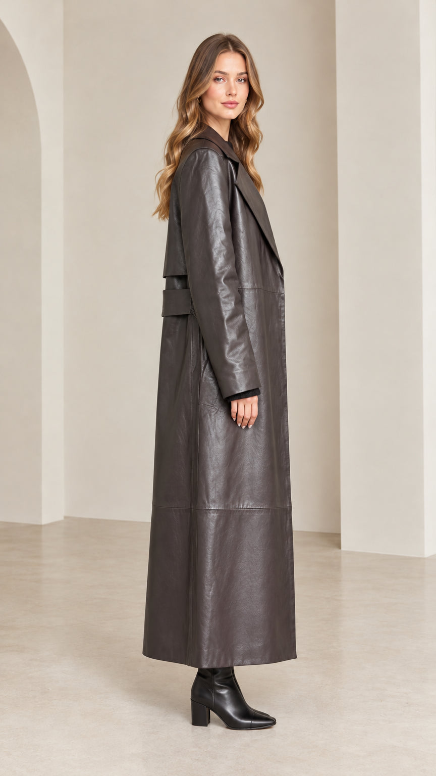 Side profile view of dark brown floor-length faux leather trench coat
