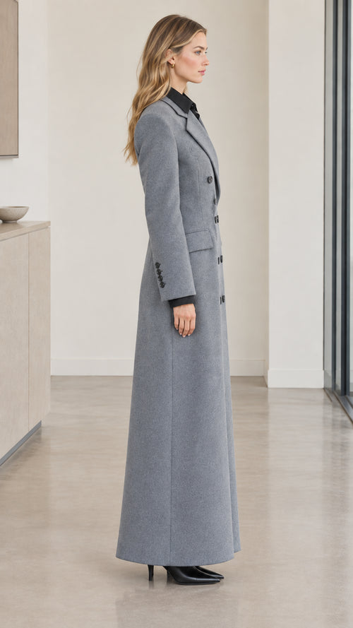 Side profile view of woman wearing grey tailored maxi coat with back vent