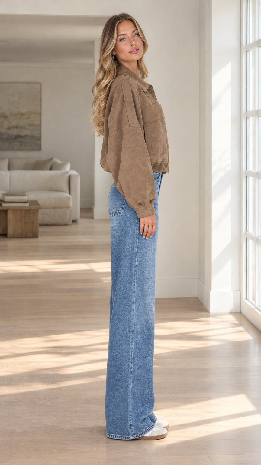 Side profile view of model wearing brown cropped faux suede jacket